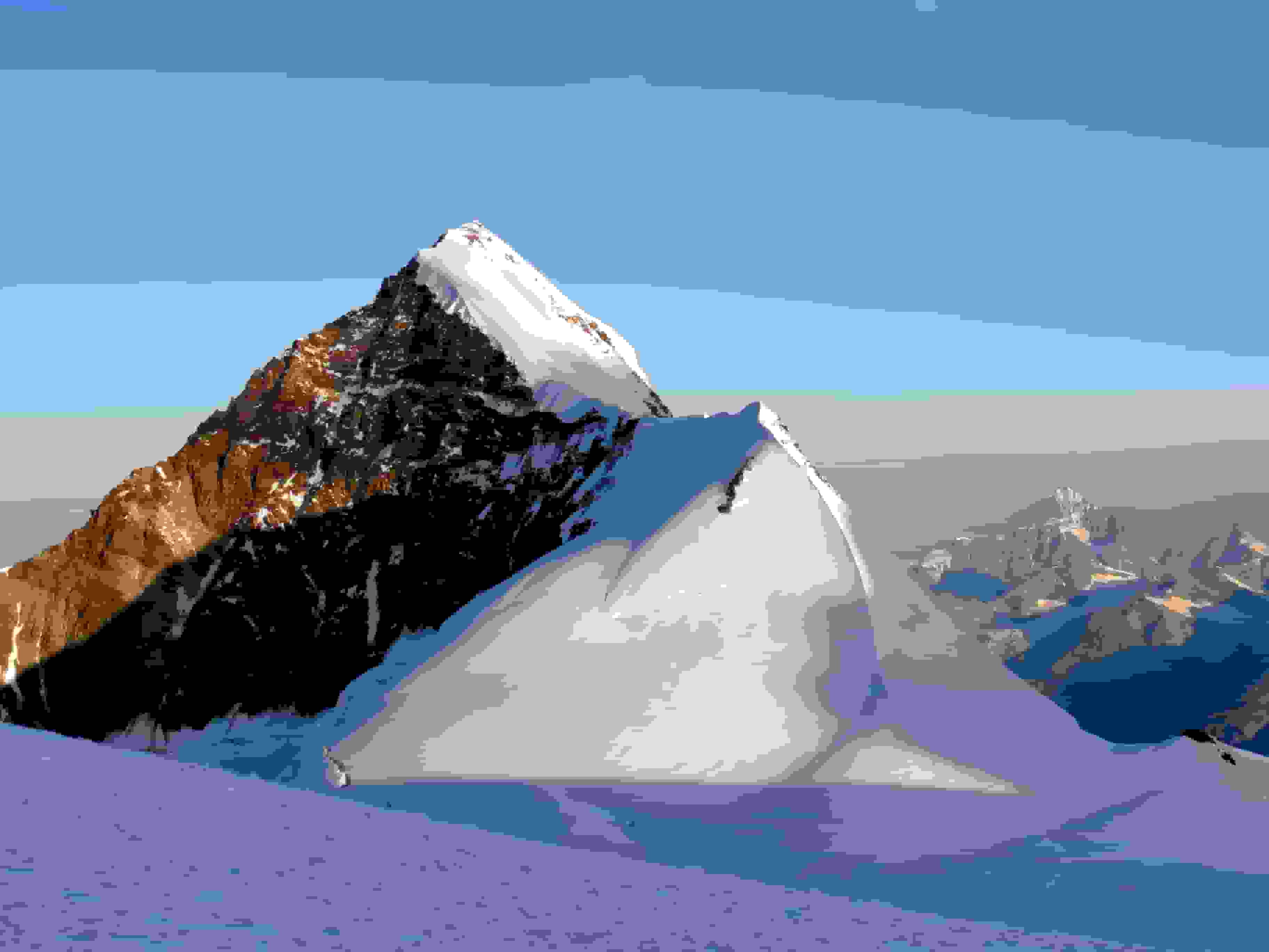 Der wunderschöne Liskamm Ostgipfel. Vom Lisjoch führt eine Spur direkt auf dem Grat hoch. Zwei weitere Spuren führen durch die sonnenbeschienene Flanke hoch zum Grat.